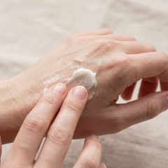 A pea-sized amount of whipped tallow being applied to the back of a hand